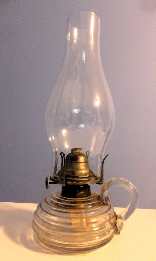 A glass oil lamp with a handle